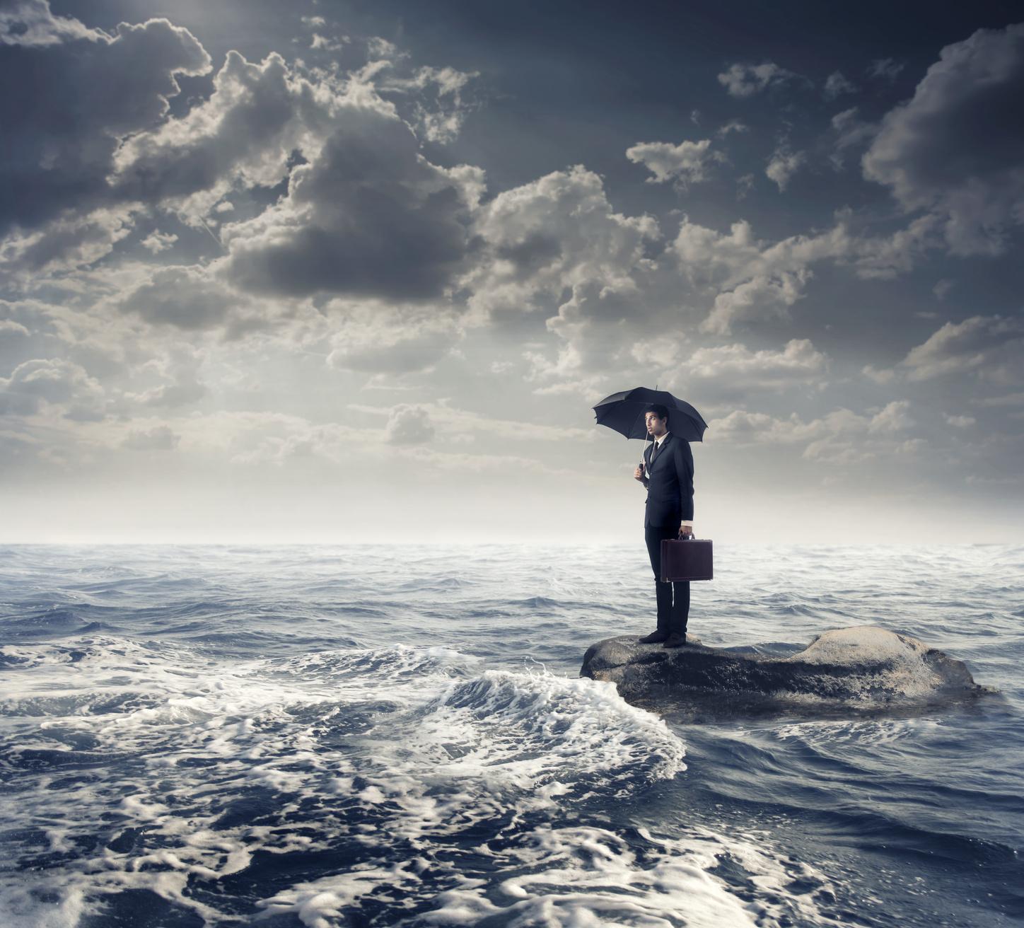 Man on rock surounded by the sea